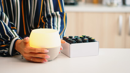 Closing lead on essential oils diffuser after adding fragrance to it. Aroma health essence, welness...