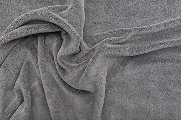 Fleece. Close-up warm, softness grey plaid on the bed, top view. Crumpled soft blanket.  