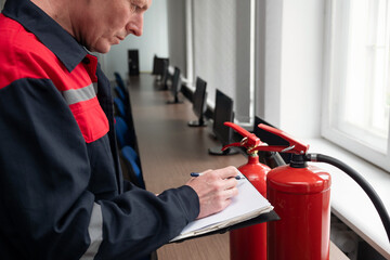 Engineer Professional are Checking A Fire Extinguisher and writes data to the check log. Fire Alarm...