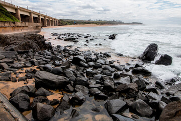 Rocks Before Cement Breakwater Leading to Bridge