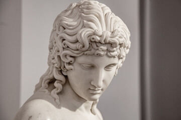 Fototapeta na wymiar Ancient white marble sculpture head of young woman. Statue of sensual renaissance art era naked woman antique style