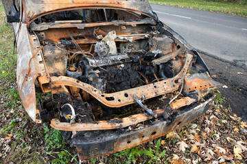 A set on fire stands on the side of a busy street next to the forest