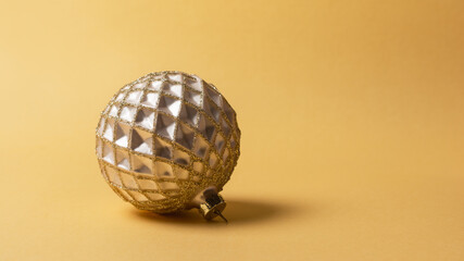 Close-up of golden christmas ball with shiny glittering
