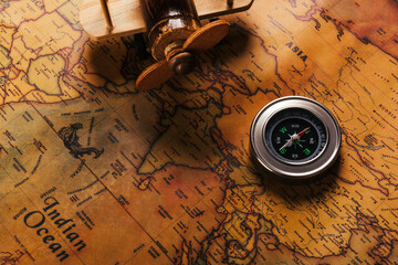 Old compass discovery and wooden plane on vintage paper antique world map background, Retro style cartography travel geography navigation, Columbus Day concept