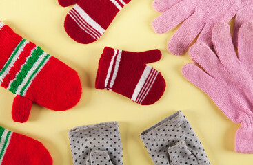 Winter colored warm gloves on an isolated yellow background.