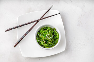 Croped photo of green wakame seaweed salad with chopstick at the restaurant © mathefoto