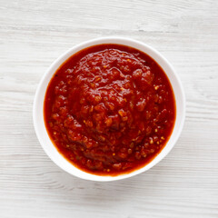 Homemade Tomato Salsa on a white wooden surface, top view. Flat lay, overhead, from above.