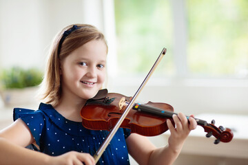 Child playing violin. Remote learning.