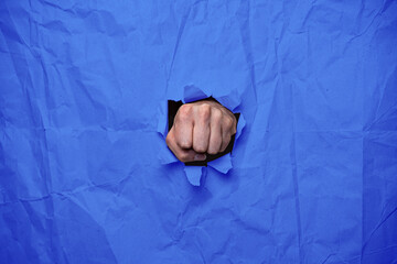 Faust Hand boxt durch Papier, blau