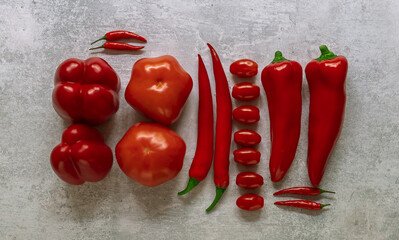 Red vegetables in knolling style on a grey background.