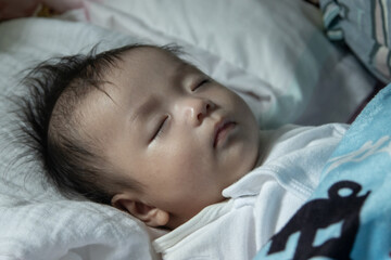 Little Asia Chinese child sleeping on bed at home