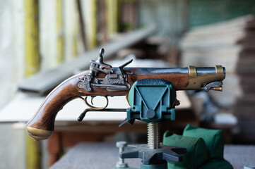 Close-up of an old Kubur pistol. Engraved Flintlock on black powder. Old weapon with wooden handle...