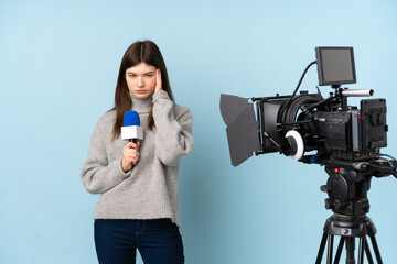 Young reporter woman holding a microphone and reporting news unhappy and frustrated with something....