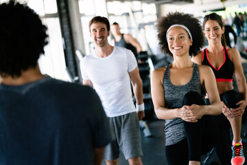 Beautiful fit people exercising together in gym