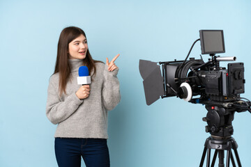 Young reporter woman holding a microphone and reporting news pointing finger to the side