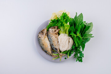 Fried mackerel served with fresh vegetable, Thai food top view


