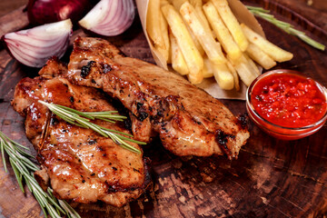 Fried meat with spices and vegetables on a wooden board. European cuisine.