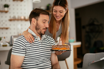 Husband's birthday. Wife surprise her husband with birthday cake..