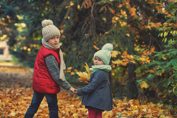 Children on an autumn walk in the park .Happy brother with sister outdoors