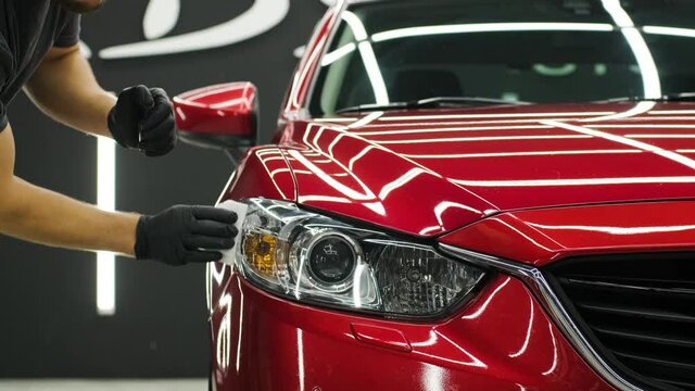Car service worker applying nano coating on a car detail.