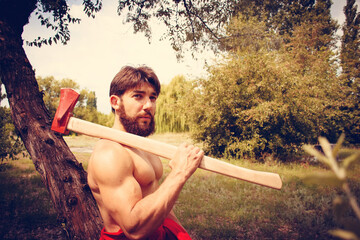 Handsome shirtless young man with axe