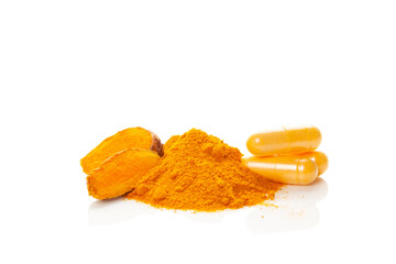 Turmeric (curcumin) powder heap, capsules and fresh turmeric root.