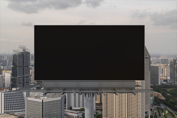 Blank black road billboard with Singapore cityscape background at sunset. Street advertising...