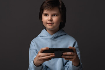 Portrait of Cute boy 10-12 years old with gamepad in hands playing video game. Childhood, facial expression concept © Red Cristal
