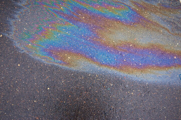 Colored oil stains close up, the color of the gasoline stain on the pavement road as a texture or background.