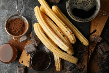 Concept of lunch with churros and chocolate on dark table