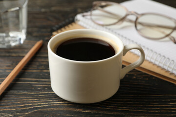 Student supplies and cup of coffee on wooden background