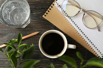 Student supplies and cup of coffee on wooden background