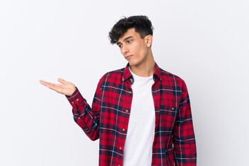Young Argentinian man over isolated white background holding copyspace with doubts