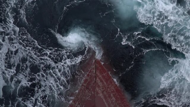 The red bow of the ship is submerged under sea water.