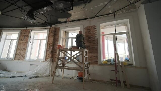 Specialist installing decorative brick tiles on the wall. Renovation in the loft style. Construction works
