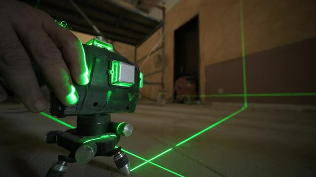 Laser measurement during renovation. Construction tools and equipment. Green laser light lines for level measure.