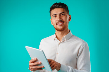 Young businessman wearing white shirt holds digital tablet