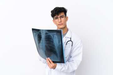 Young Argentinian man over isolated white background wearing a doctor gown and holding a bone scan