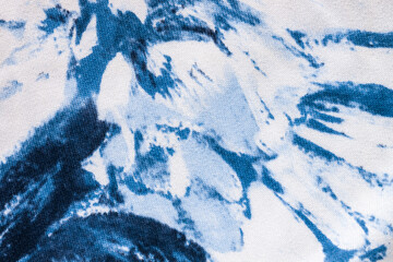 Tie-dye cotton fabric texture blue and white paint colors. Ancient resist-dyeing textile coloring technique, saturated primary colors, bold patterns, simple motifs, monochromatic color schemes garment