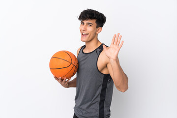 Basketball player man over isolated white background saluting with hand with happy expression