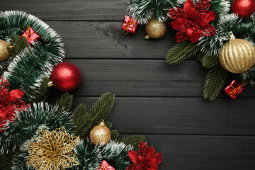 Christmas frame with Christmas decorations on black wooden background.