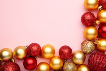 Red and gold christmas balls on pink background with copy space.