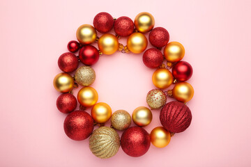 Red and gold christmas balls on pink background with copy space.
