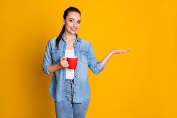 Photo of positive confident girl promoter hold hand display option adverts promo drink cup latte wear good look clothes isolated over bright color background