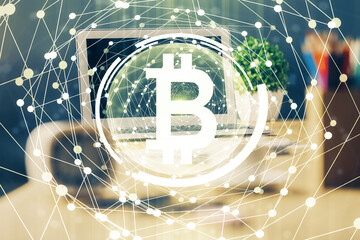 Double exposure of blockchain theme hologram and table with computer background. Concept of bitcoin crypto currency.