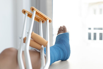 Young man was wearing a blue cast and had crutches.