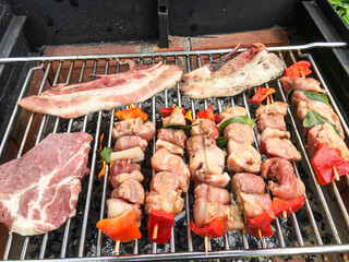 Spiedini di carne e ortaggi, carne e pancetta in cottura sulla brace