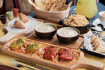 Having tandoori chicken and fish, friend rice, samosa and naan bread in Indian restaurant