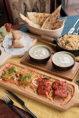 Having tandoori chicken and fish, friend rice, samosa and naan bread in Indian restaurant