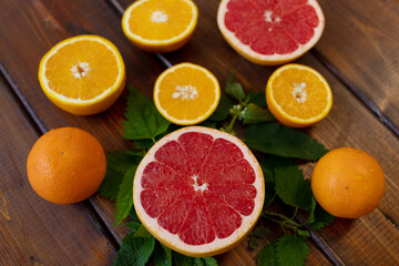 oranges and grapefruit on a brown wooden background, top view, text space, citrus